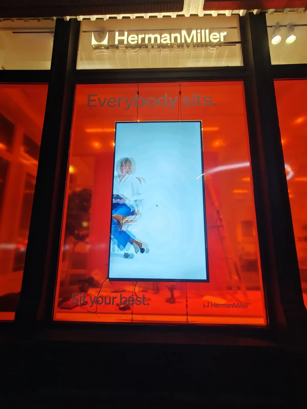 Samsung QM75C 75-inch display hung in portrait on cables at the Herman Miller Park Avenue showroom, installed by CrownTV