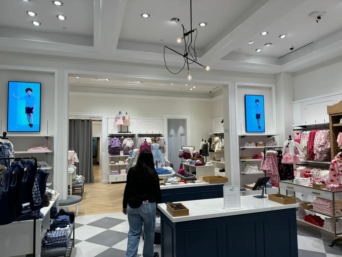 Janie and Jack store interior with Samsung QM55C displays mounted in portrait above the shelving, installed by CrownTV