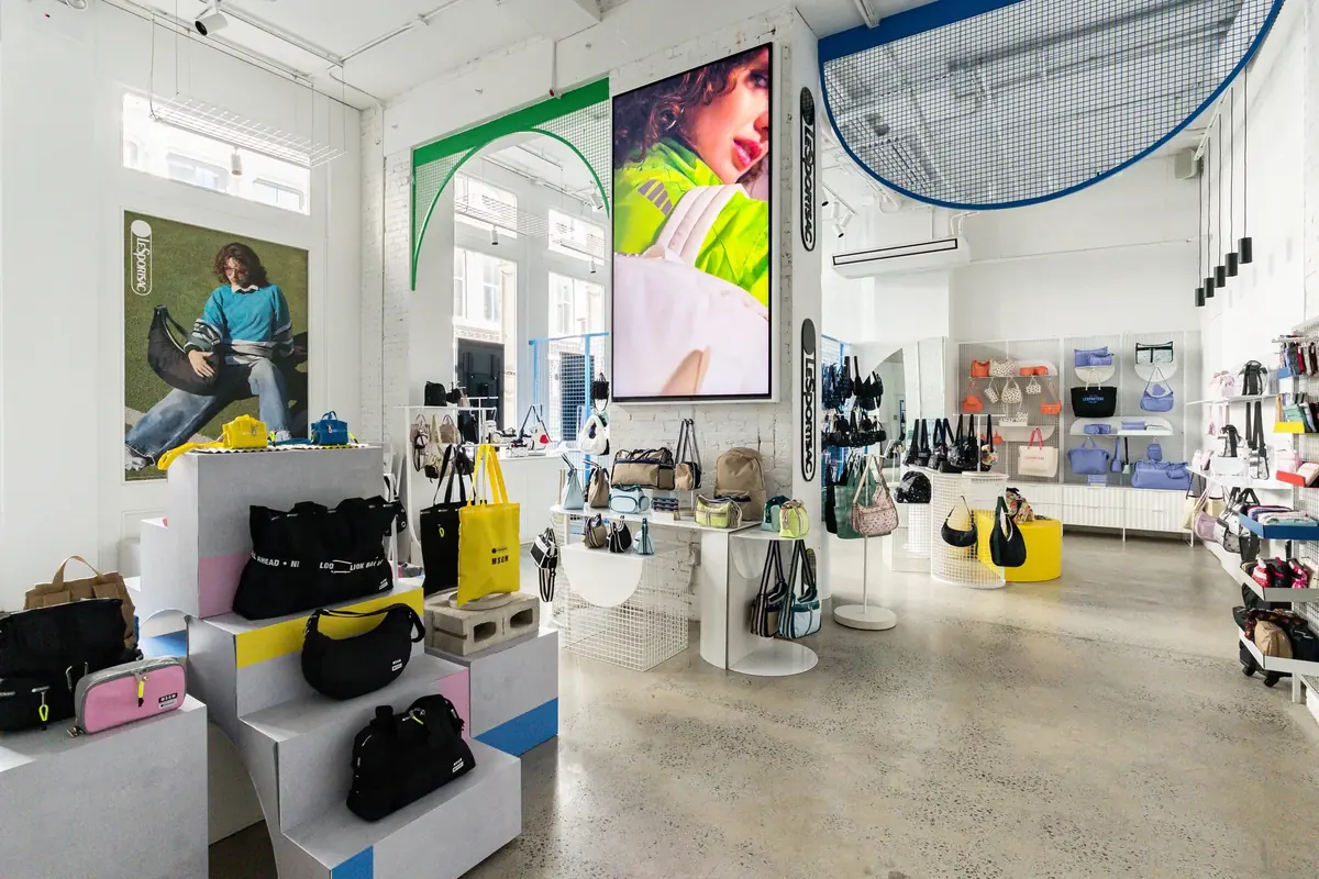 LeSportsac SoHo flagship interior with a 98-inch Samsung QM98C display on the wall, installed by CrownTV